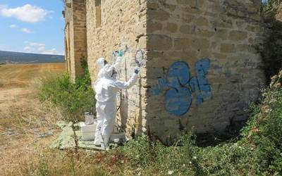 Urrialdoko baselizako pintadak garbitzeari ekin diote