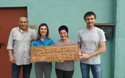 Dorletako Ama Txirrindulari Eskolari egurrezko plaka oparitu diote tailaginek