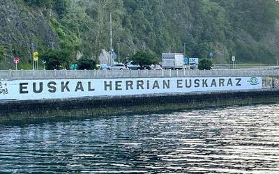 Herritar talde batek Debako itsasadarreko 'Euskal Herrian Euskaraz' murala berritu du